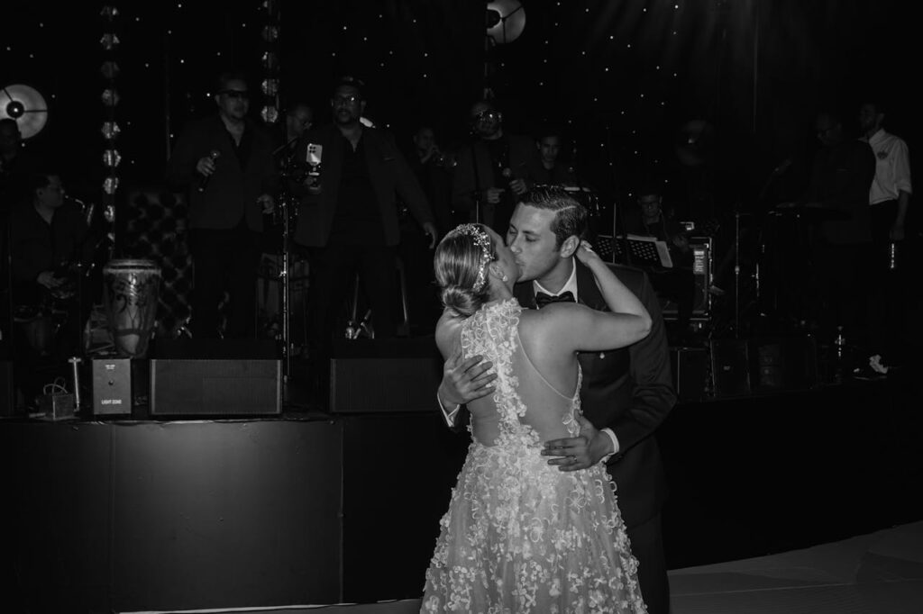 Bride and groom sharing a kiss during their first dance at a wedding reception.